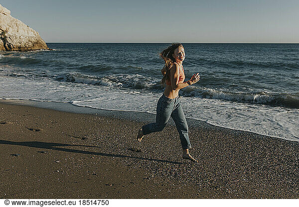 Happy woman running at beach