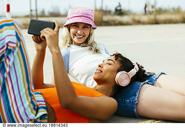 Happy woman spending leisure time with friend on footpath