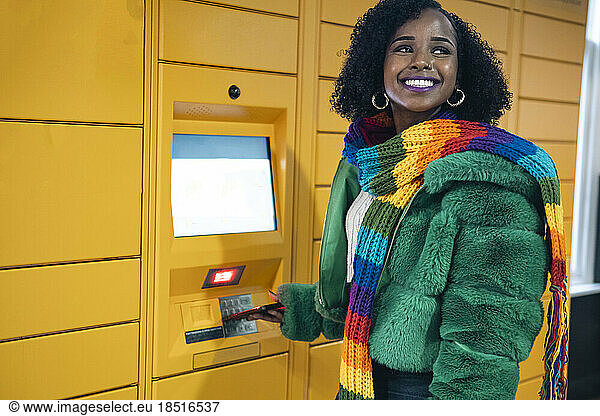 Happy woman standing near ticket vending machine