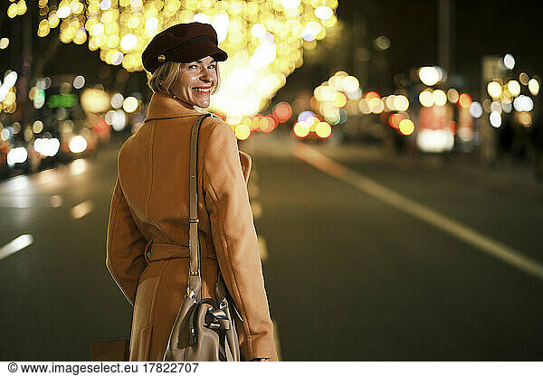 Happy woman standing on road in city