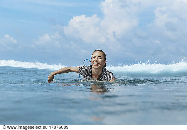 Happy woman swimming in sea on sunny day