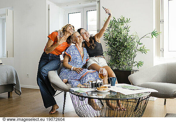 Happy woman taking selfie with friends through smart phone