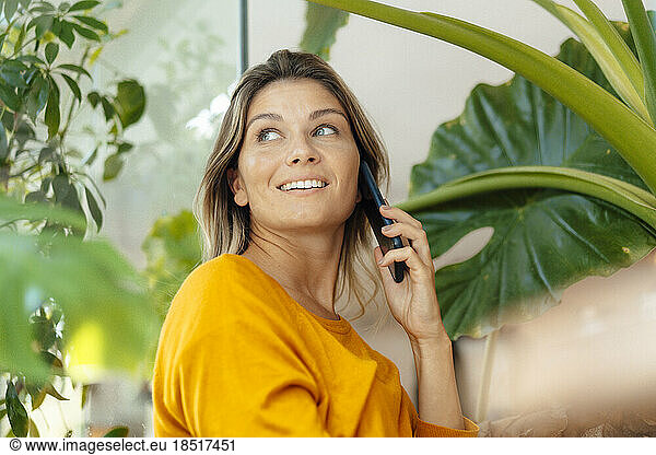 Happy woman talking on mobile phone in cafe