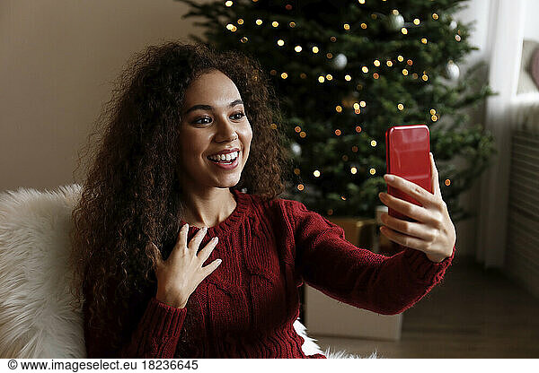 Happy woman talking on video call through smart phone