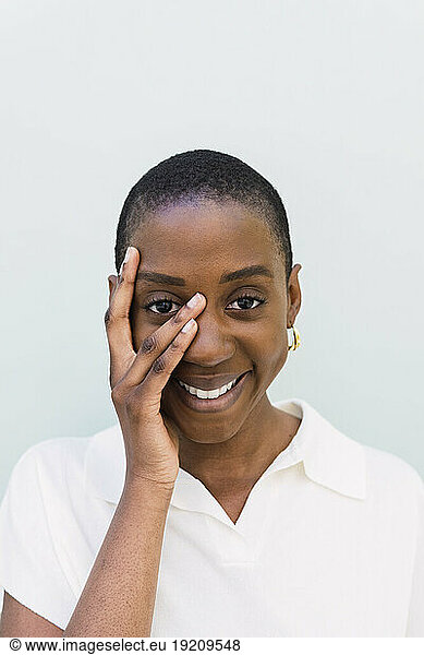 Happy woman touching face against white background