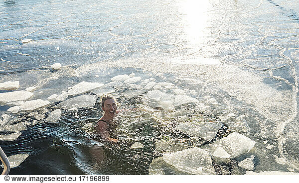 Happy Woman Treading Water With Ice In The Ocean In Denmark