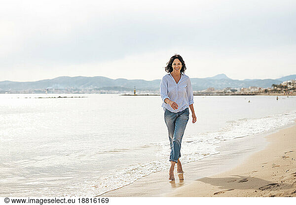 Happy woman walking near sea at beach