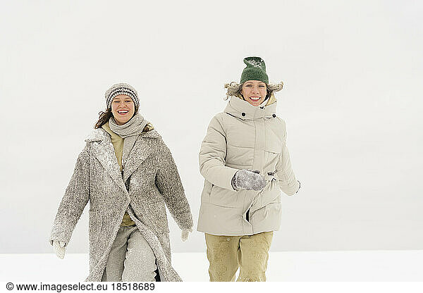 Happy woman walking with friend in winter