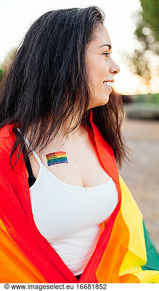 Happy woman with an lgtb flag and a gay pride tattoo on her chest