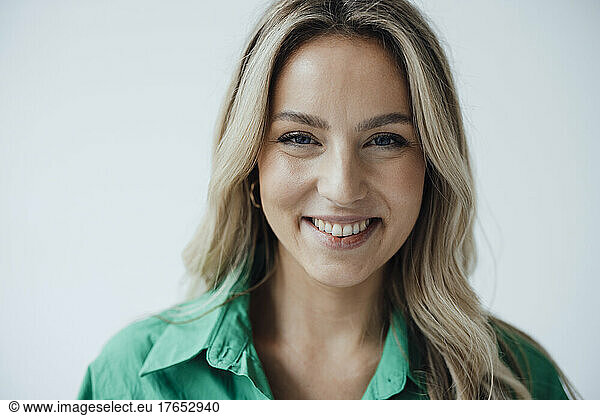 Happy woman with blond hair against white background