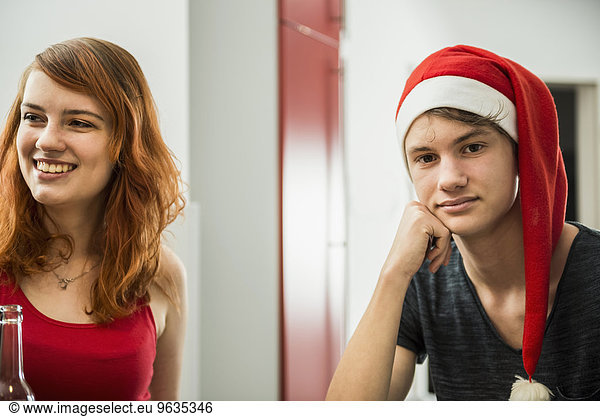 Happy woman with bored young man on Christmas eve