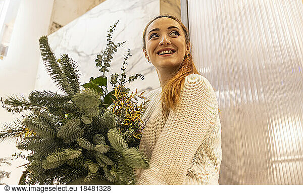 Happy woman with coniferous plant