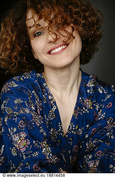 Happy woman with curly hair wearing floral dress
