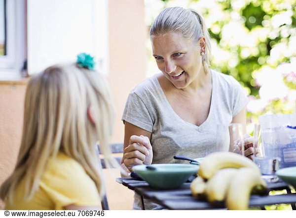 Happy woman with daughter at breakfast table
