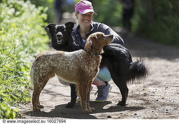 Happy woman with dogs on hiking trail