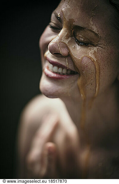 Happy woman with liquid on face at health spa