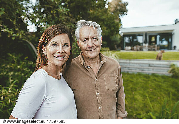 Happy woman with senior man standing in garden