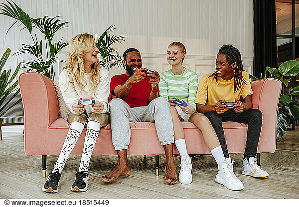 Happy women playing video game with friends at home