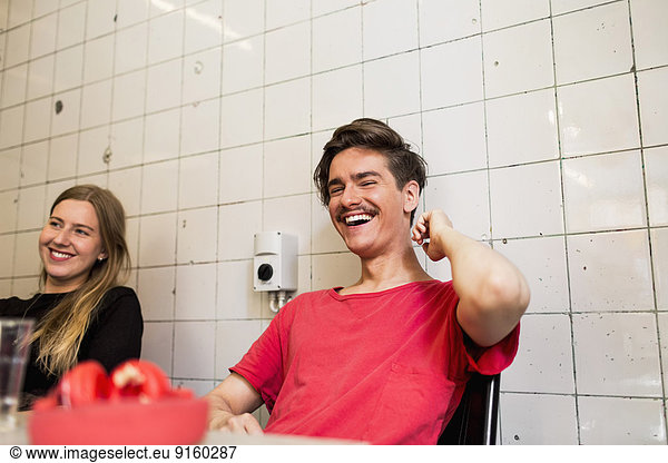 Happy young businessman with female colleague in small office