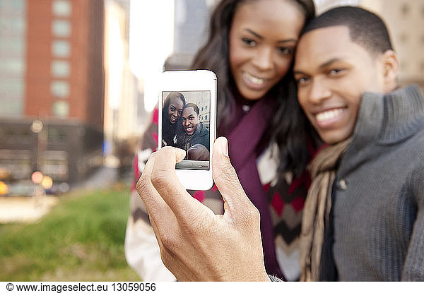 Happy young couple clicking selfie with smart phone