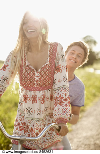 Happy young couple enjoying bicycle ride at countryside