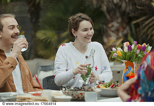 Happy young couple enjoying lunch at patio table