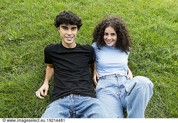 Happy young couple relaxing on grass