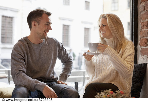 Happy young couple spending leisure time at cafe