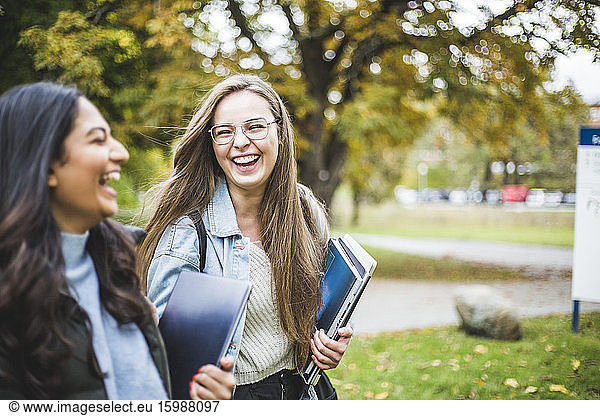 Happy young female friends in university campus