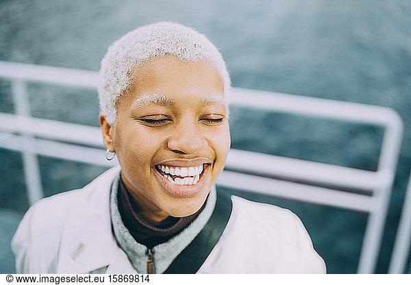 Happy young female with eyes closed standing in ship