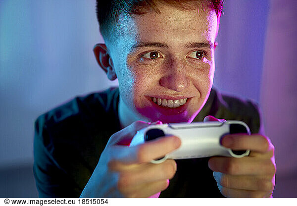Happy young man playing video game