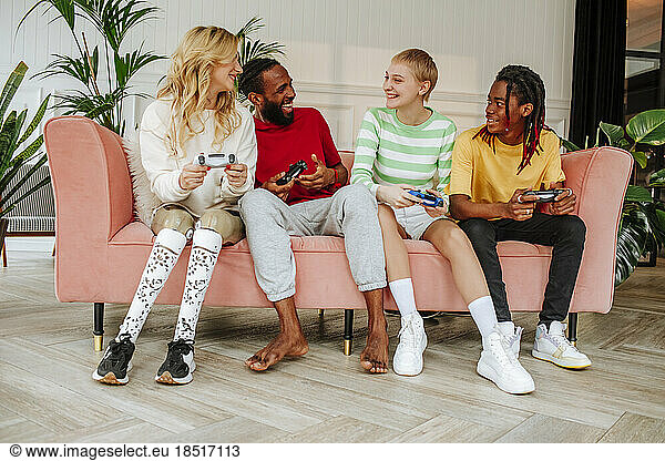 Happy young man with friends enjoying video game at home