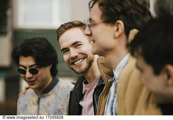 Happy young man with male friends