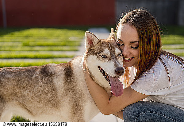 Happy young woman cuddling her dog