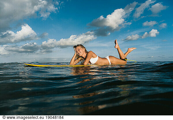 Happy young woman on a surfboard in the ocean  Bali.