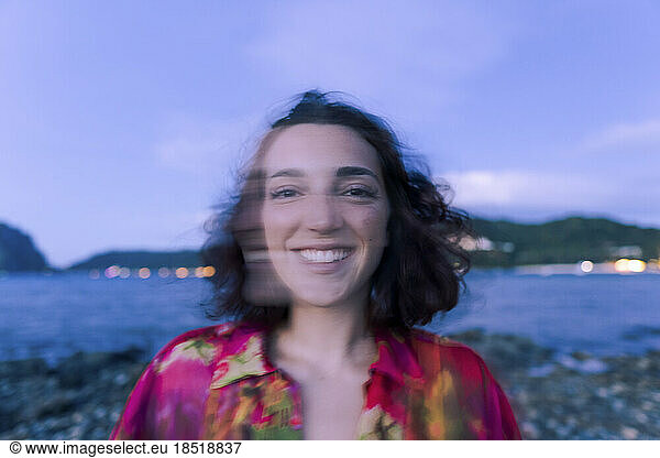 Happy young woman on beach at dusk