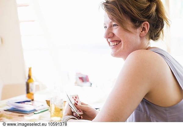 Happy young woman playing card game