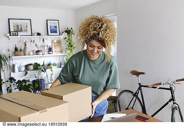 Happy young woman shipping packages