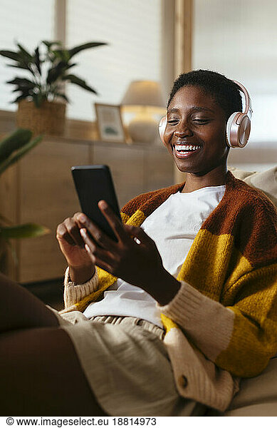 Happy young woman watching movie on smart phone