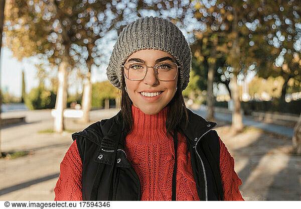 Happy young woman wearing knit hat and eyeglasses