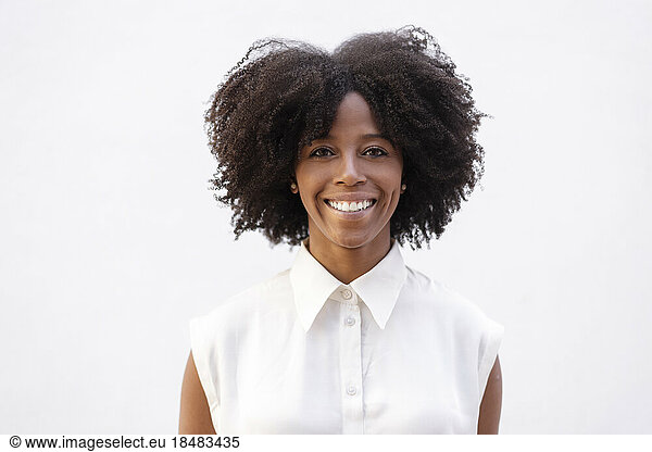 Happy young woman with Afro hairstyle against white background