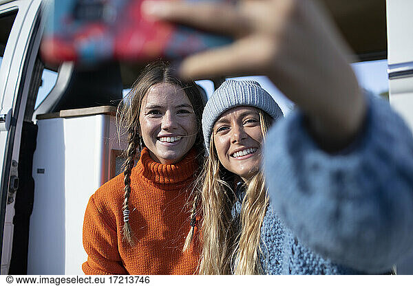 Happy young women friends taking selfie