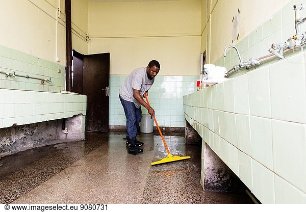 Harmanli  Bulgaria. African refugee cleaning the bathroom in one of the many refugee centre's residential buildings.