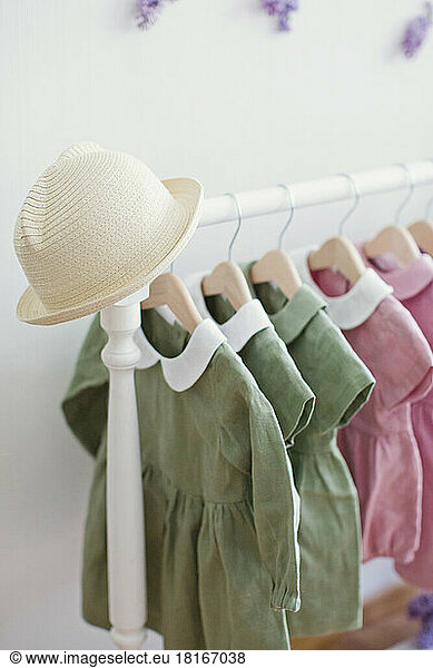 Hat on rack with dresses hanging in store