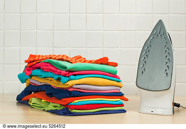 Haufenweise saubere Wäsche und Bügeleisen