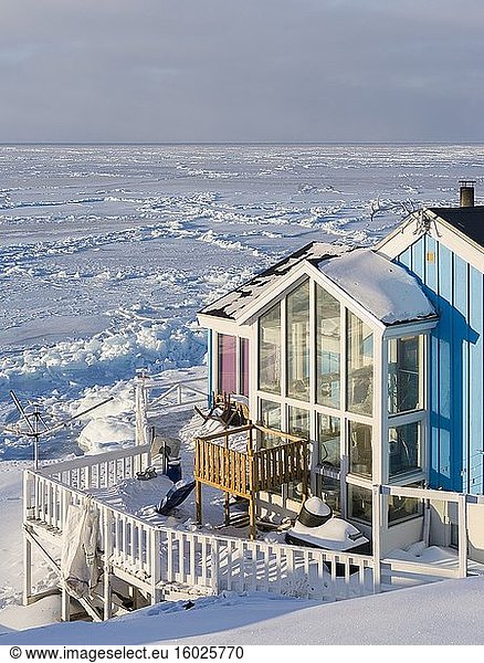 Haus mit Blick auf die zugefrorene Diskobucht. Winter in Ilulissat am Ufer der Diskobucht. Amerika  Nordamerika  Grönland  Dänemark