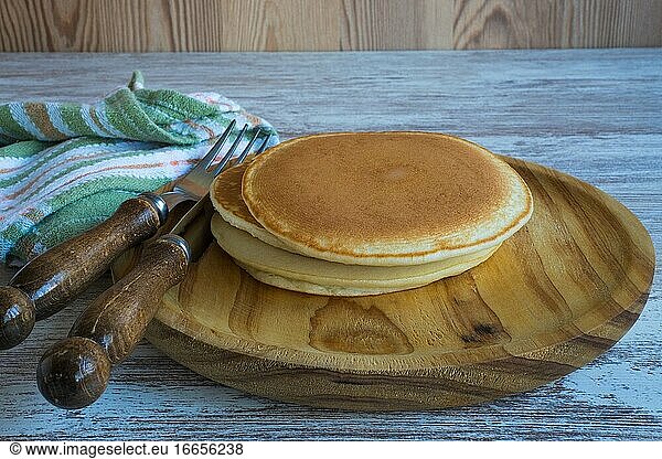 Hausgemachte Pfannkuchen auf einem Holzteller.
