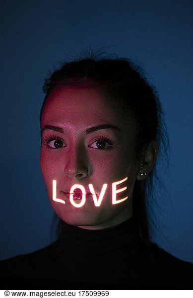 Headshot of woman with word Love on her face