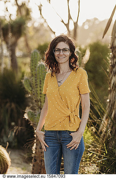 Headshot portrait of mid adult female mother with glasses  outside