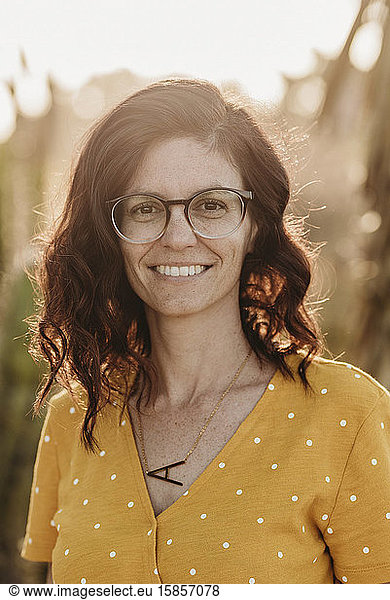 Headshot portrait of mid adult female mother with glasses  outside